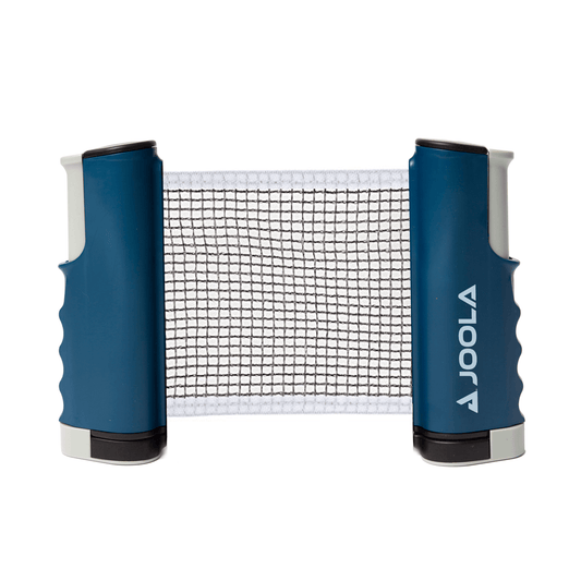 White Background Image: JOOLA Outdoor Table Tennis Table with navy blue net posts with horizontal JOOLA logo in white on the right post