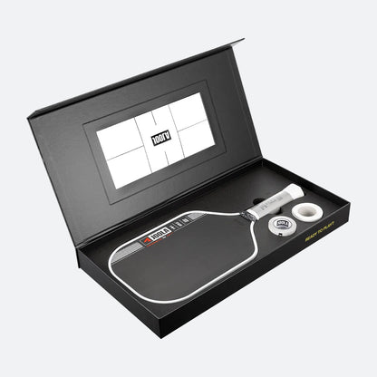 Pickleball paddle and ball set in a black box with a visible brand logo.