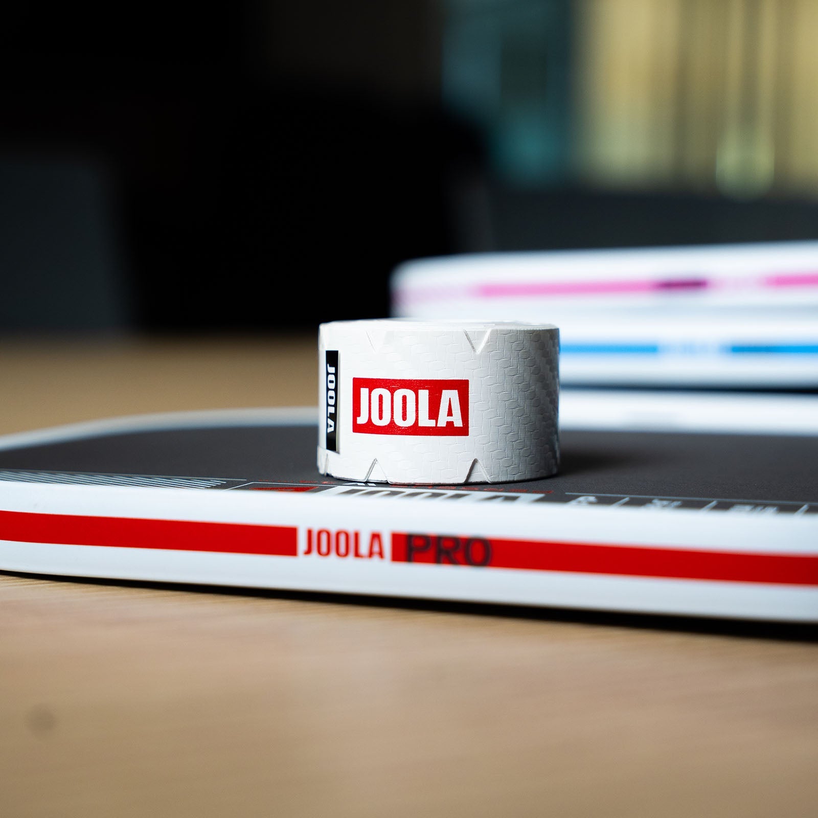 Close-up of a roll of JOOLA Pro IV pickleball paddle with JOOLA Pro IV tape on a blurred background.