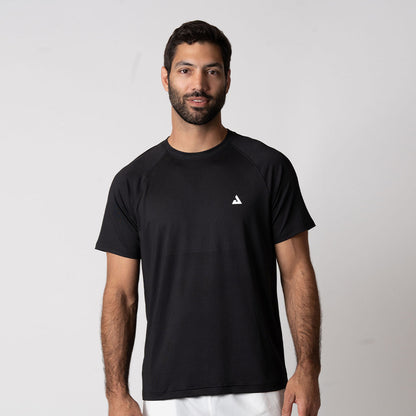 Gray background, image of a male model wearing the JOOLA Men's Court Short Sleeve shirt, black.