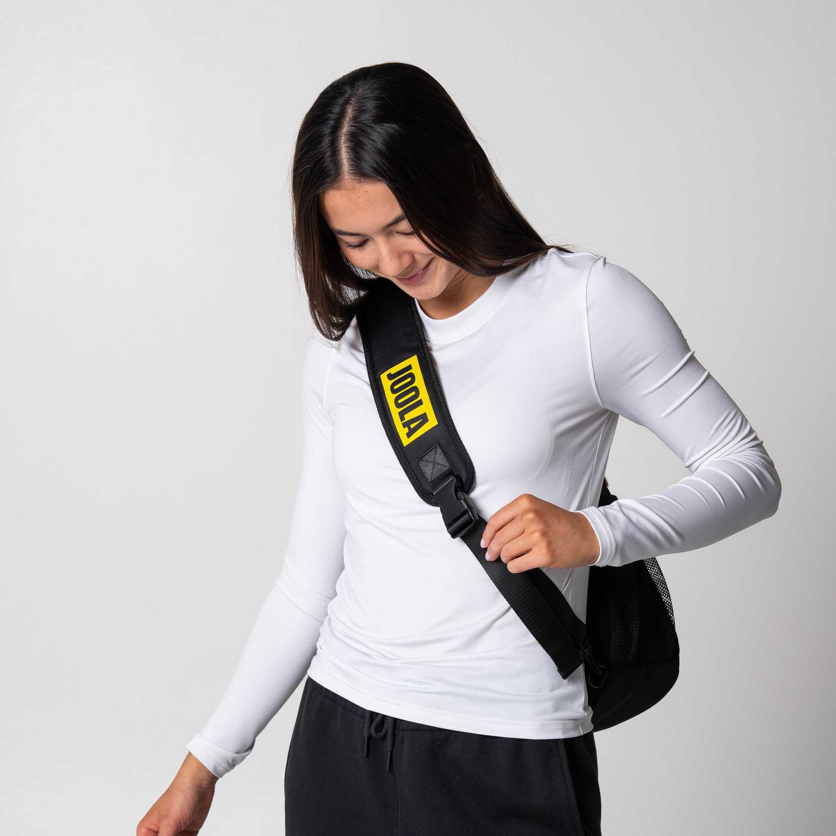 Gray background, mage of the front strap of the JOOLA Sling Bag.