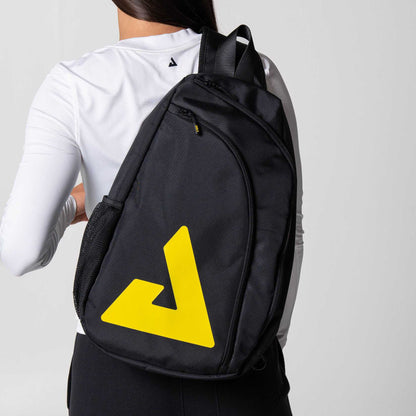 Gray background, image of a female model with the JOOLA Sling Bag over her shoulder.