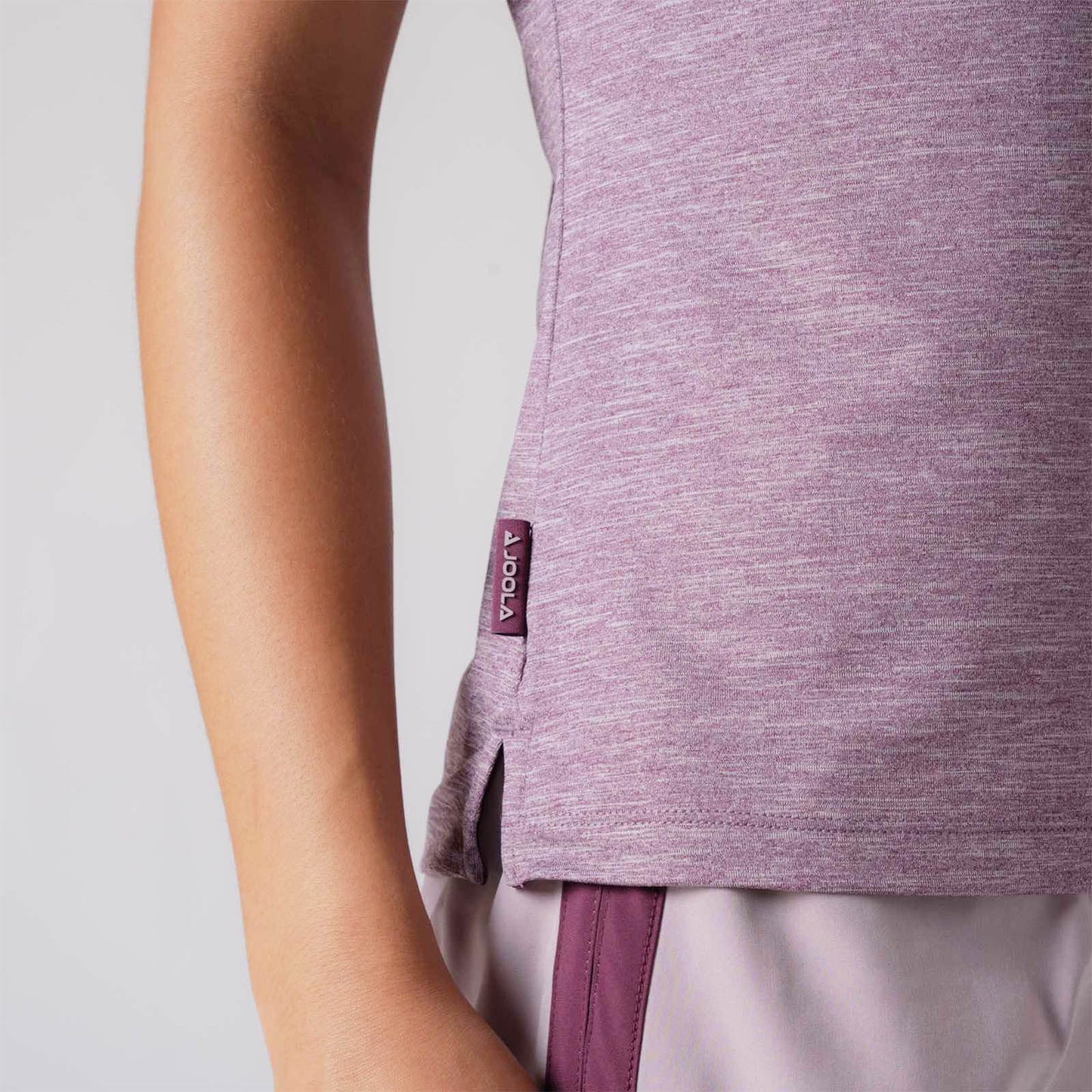 Close up image showing the raised JOOLA logo tag on the side of a JOOLA women's club polo, Bordeaux heather.